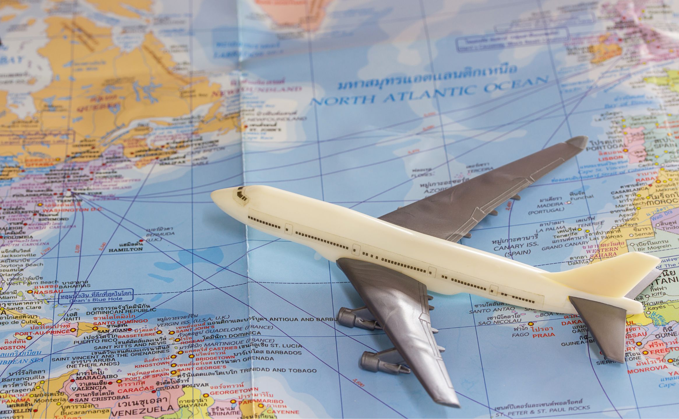 世界地図の上に乗っている飛行機の模型